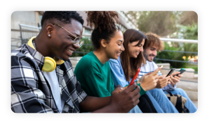 Group of happy multiracial teenage college friend students ignoring each other looking at mobile phone.