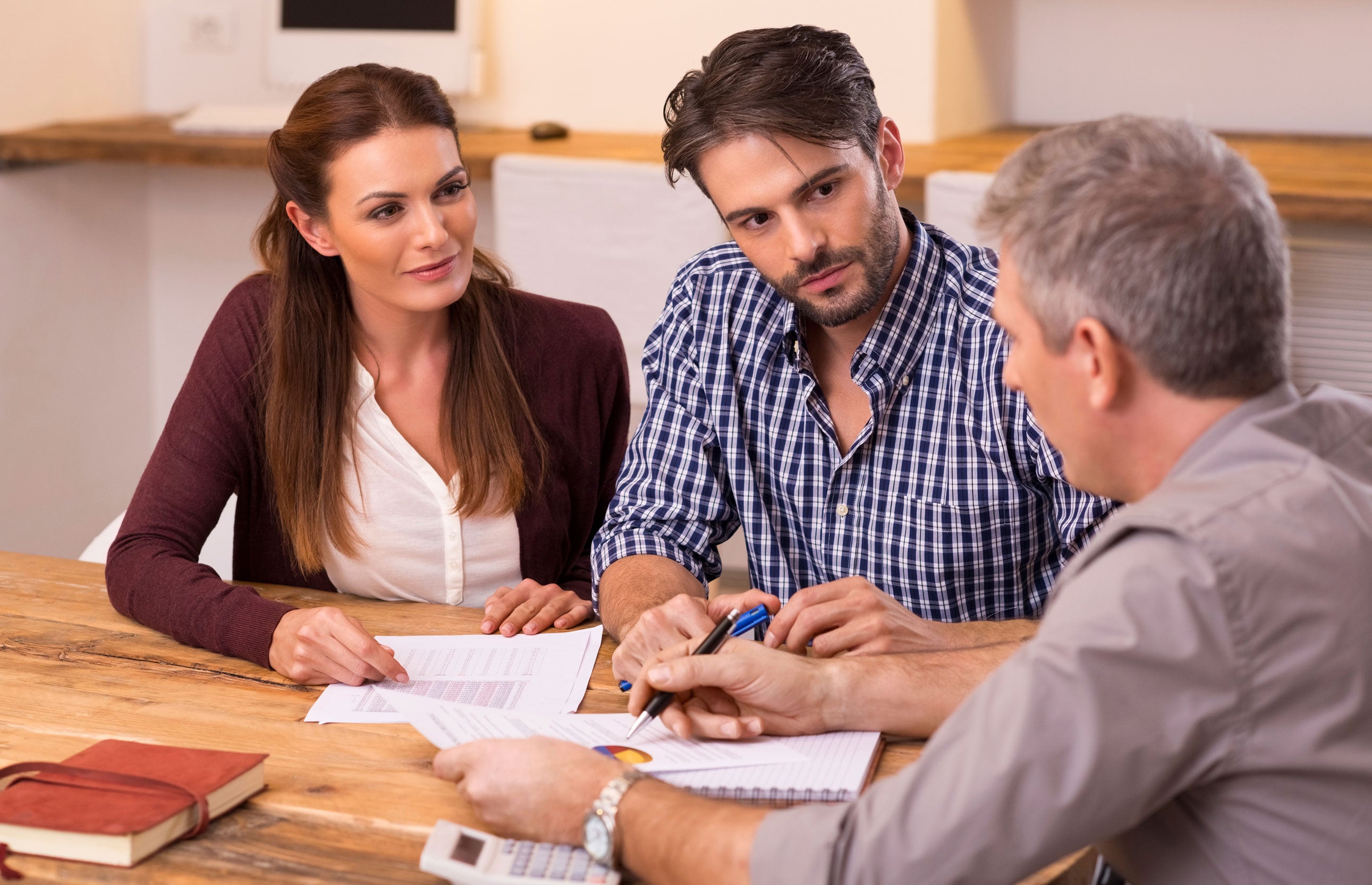 A couple speaks with a professional about whether to get an FHA or conventional loan