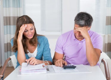 Worried Couple Looking At Unpaid Bills At Home
