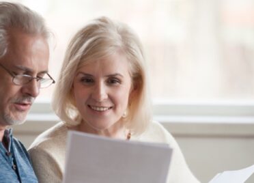 A happy elderly couple looks over the new payday loan regulations.