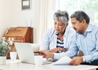 An elderly couple sits at their couch contemplating the question, "Does opening a CD affect my credit rating?"