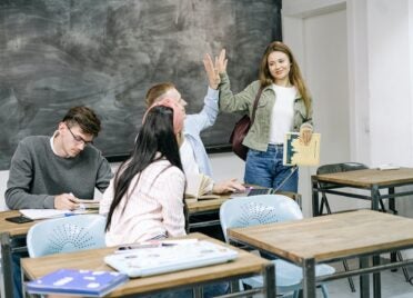 High school students high five in a classroom.