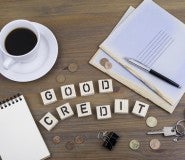 Good Credit spelled in scabble letters with copy cup and papers to s how you can improve credit score