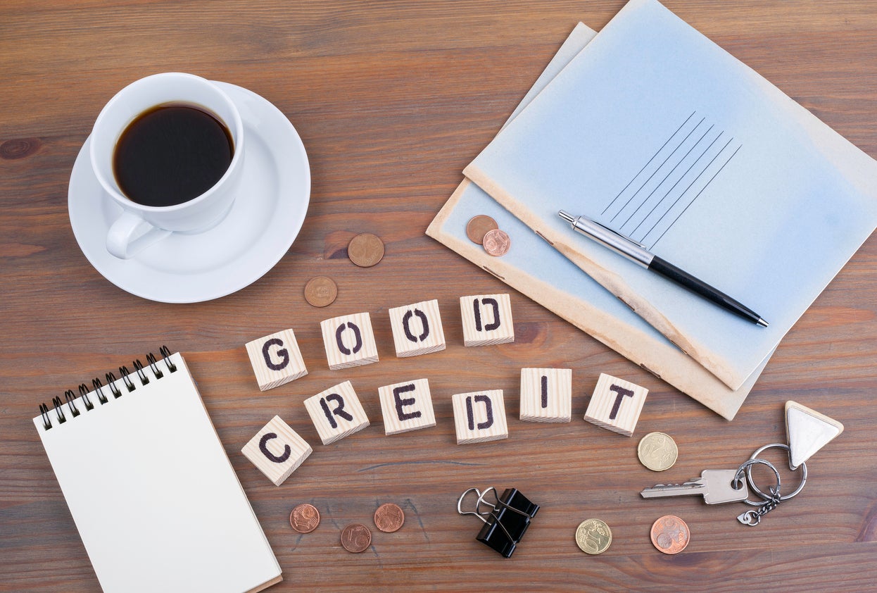 Good Credit spelled in scabble letters with copy cup and papers to s how you can improve credit score