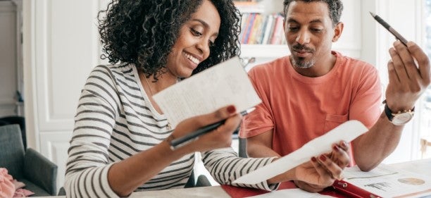 couple with papers figuring out how to budget