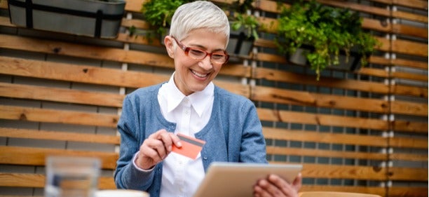 Senior woman opening savings account online using laptop