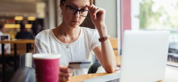 woman in cafe thinking about credit cards for bad credit