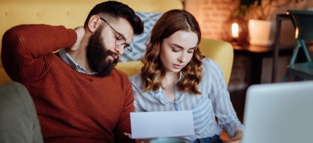 A couple, who needs credit repair, looks at their credit score.