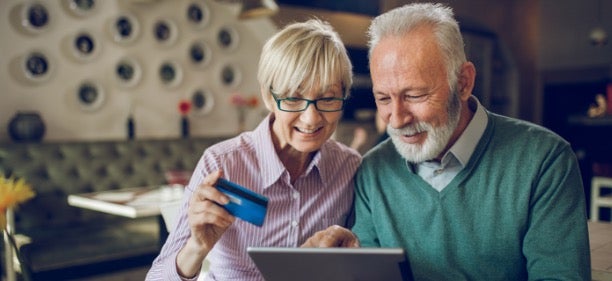 An elderly couple uses their Avant credit card.